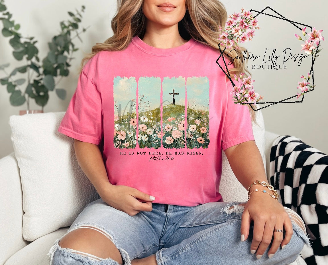 Christian He Is Risen t-shirt – Comfort Colors Easter faith-based graphic tee with Matthew 28:6 Bible verse and floral cross design.