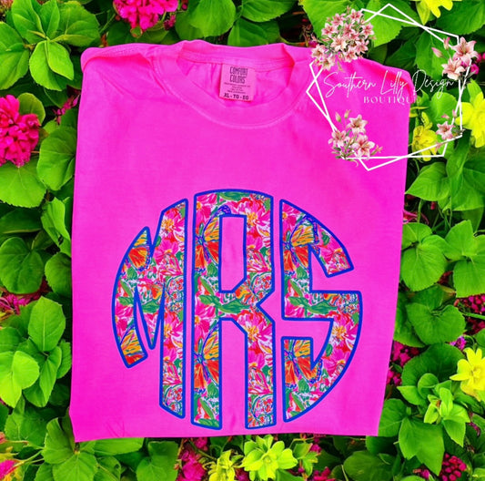 Pink t-shirt with colorful 'MRS' design on a floral background