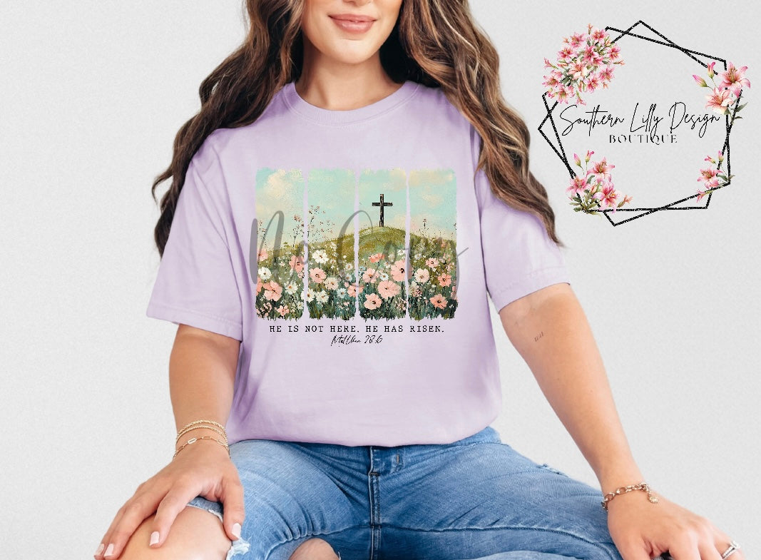 Christian He Is Risen t-shirt – Comfort Colors Easter faith-based graphic tee with Matthew 28:6 Bible verse and floral cross design.